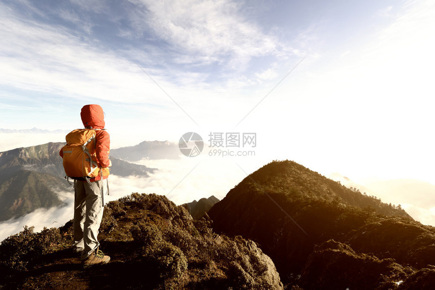 在山峰上徒步旅行的年轻女子背包客图片