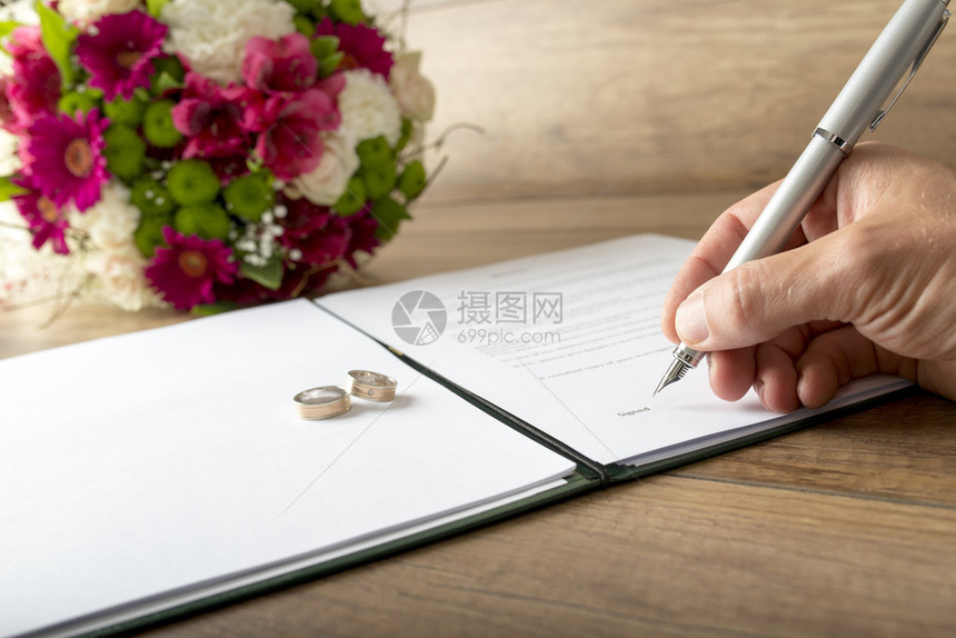 男子以新郎或证人身份签署结婚登记簿图片