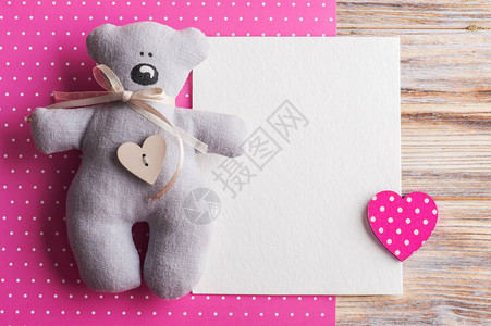 粉红色波尔卡圆点背景和泰迪熊与心脏的白卡淋浴派对图片