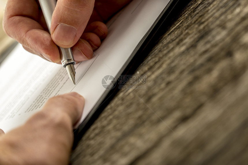 对男手签合同文件或申请表的低角近视图片