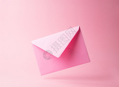 粉红色的信封掉在粉红色的背景上图片