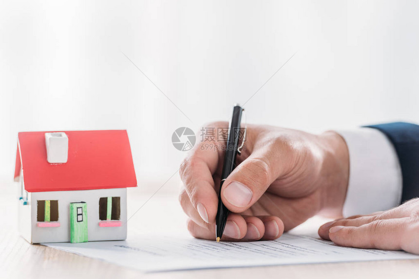 以贷款协议形式在桌面上靠近房屋模型附近写图片