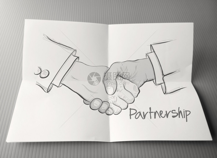 作为伙伴关系业务概念在折叠纸上用手牵图片