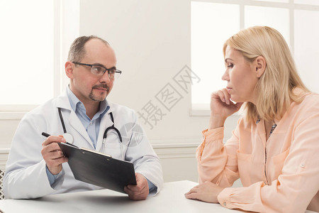 严肃的医生咨询女并展示她的测试结果医疗保健和医疗概图片