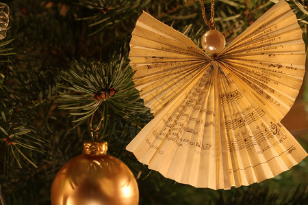 将祈祷书纸折成的圣诞树天使装饰背景图片