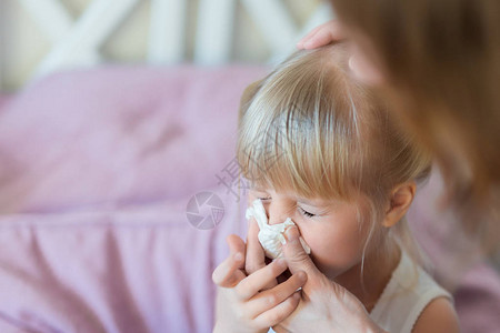 流鼻涕的孩子妈用纸巾帮孩子擤鼻涕图片