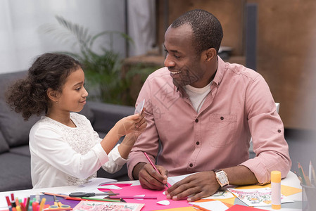 微笑的非洲裔美国父亲和女儿在母亲节制作贺卡图片