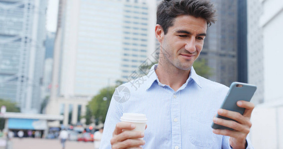 拿着手机喝咖啡的男人图片