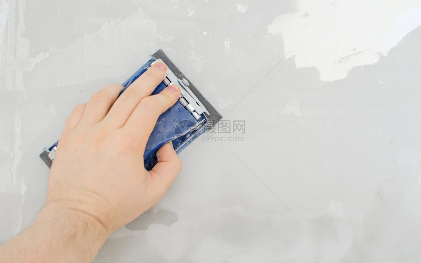 男手用砂纸磨墙图片