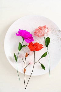 大装饰陶瓷盘上的粉红色手工纸花图片