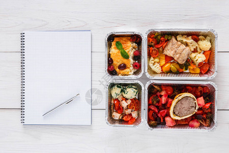 饮食计划每天新鲜的饭菜箔盒和记事本中的健身营养蔬菜肉类和水果图片