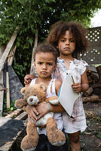 可怜的非裔美国小孩拿着白纸和铅笔图片