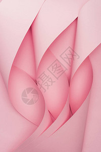 粉红色背景上粉红色纸漩涡的顶部视图图片