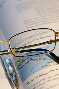 眼镜和笔放在旧书上背景图片