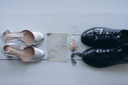 带贺卡和钻戒的新娘和新郎鞋顶视图背景图片