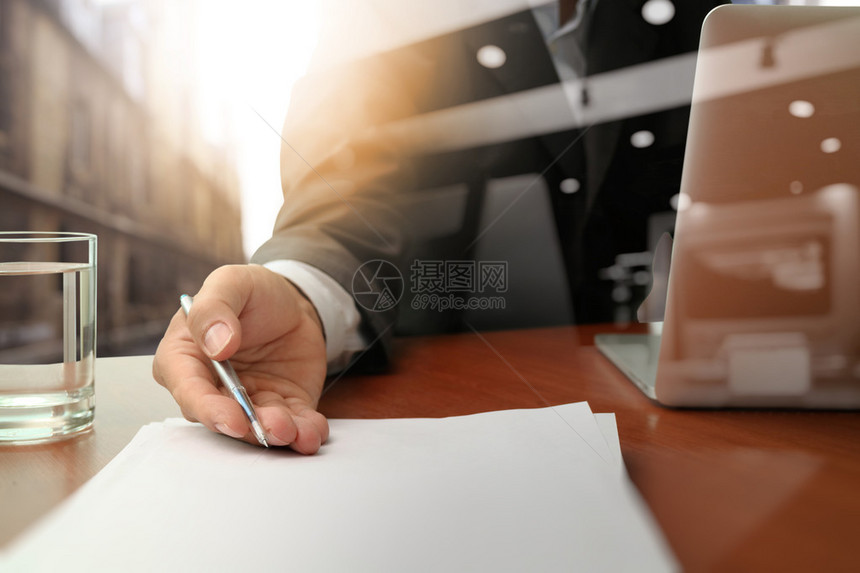 商人或销售员在木制办公桌上移交合同的图片