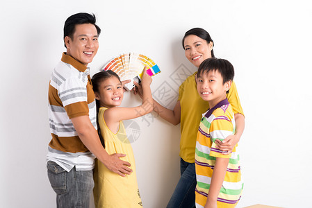 幸福的家庭选择颜色来粉刷墙壁图片