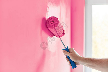 带油漆滚筒的男手绘墙粉刷公寓用粉图片