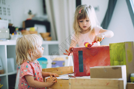 可爱小女孩的肖像在家庭绘画纸盒和图片