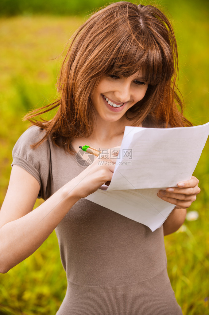 快乐笑容的年轻女人在纸页图片