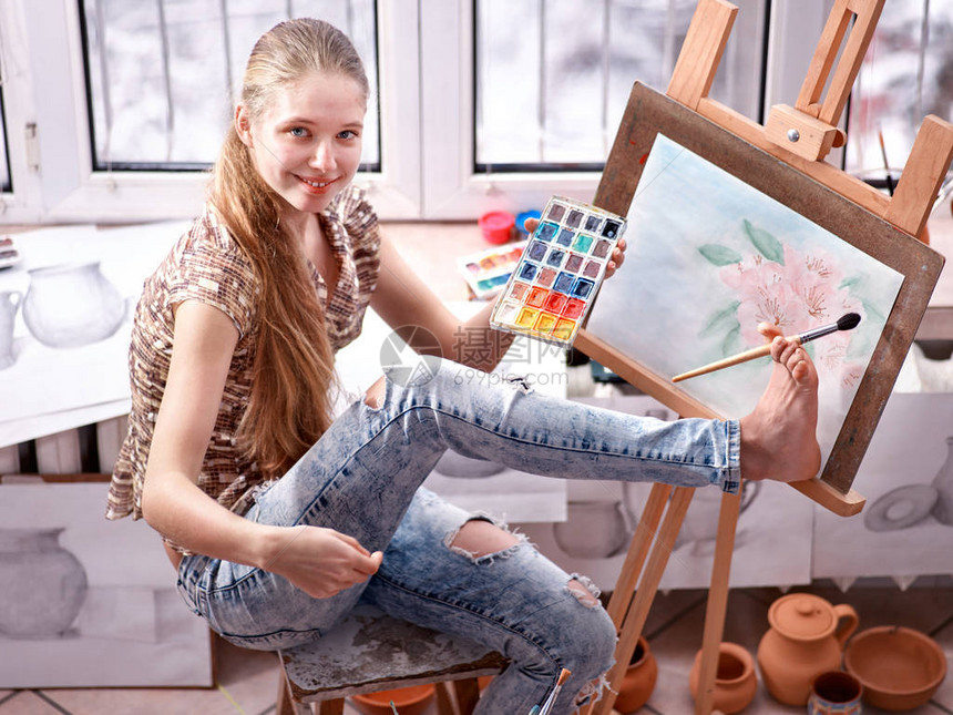 艺术家在工作室的画架上绘画正宗女孩在晨光黎明色调下用刷子绘画的自我表达用脚画学校图片图片