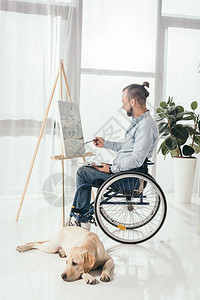 残疾人在轮椅上绘画时而他的图片