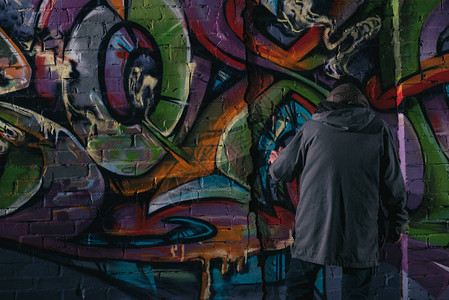 街头艺术家在夜幕上墙涂喷雾涂图片