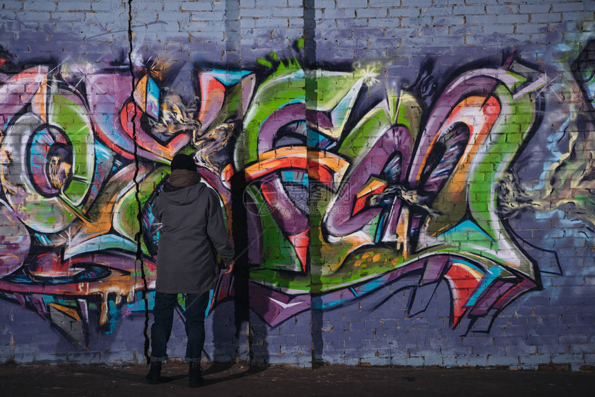 街头艺术家在夜间墙上画彩色涂图片