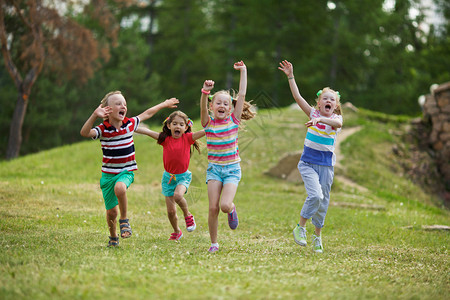 欣喜若狂的孩子们在绿色草坪上奔跑图片