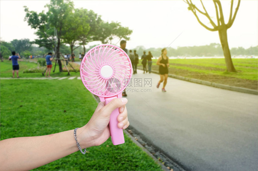 夏季炎热天气时在公共园手持粉红图片