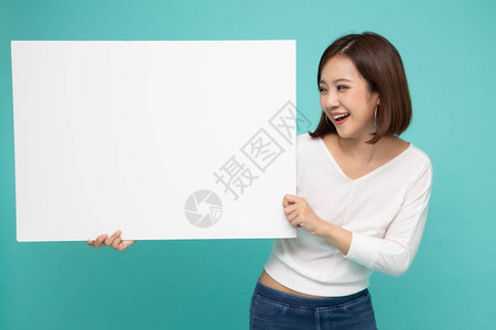 年轻漂亮的亚洲女展示并拿着空白板背景图片
