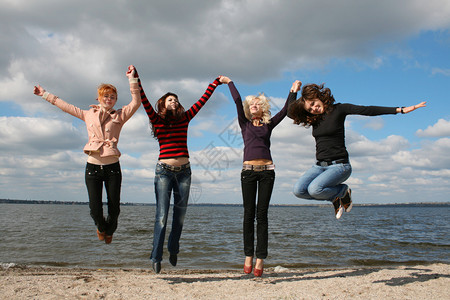 女孩们在沙滩上跳起来图片