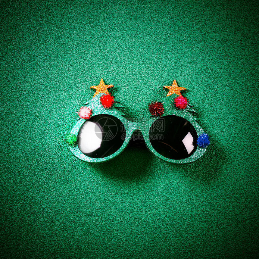装饰圣诞树的圣诞眼镜和绿色背景红图片