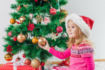 快乐的小女孩圣诞礼物和冬树家里图片
