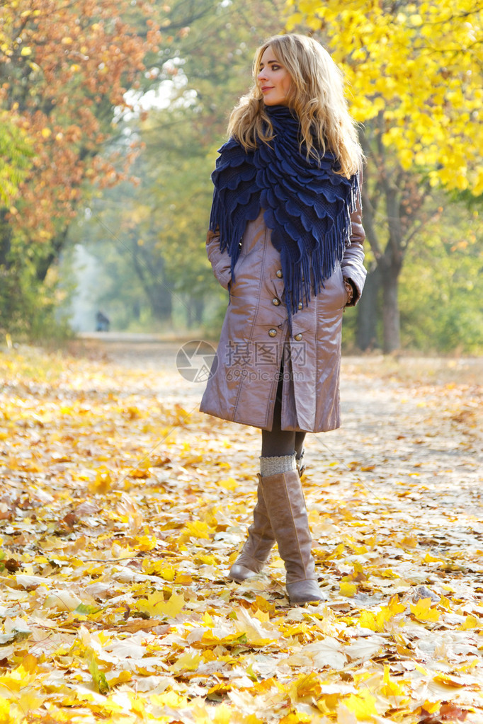 年轻漂亮的女人在秋天的公园里图片