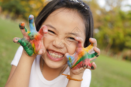 亚洲小女孩双手涂着五颜六色的颜料图片