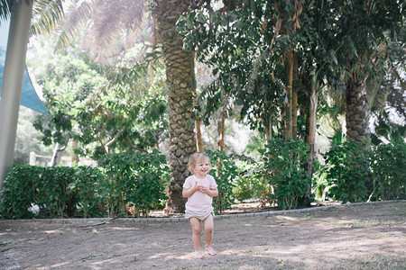 可爱的女婴在热带花园玩图片