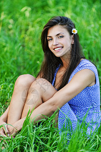 坐在绿草花耳朵边上微笑着的绿色草地背景美丽的深色图片