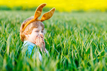 在户外玩传统的复活节彩蛋庆祝复活节假期蹒跚学步的孩子在绿草丛中发现五图片