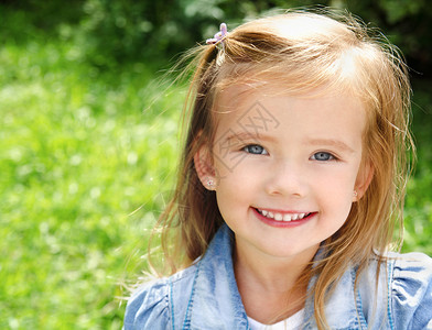 可爱微笑小女孩的户外肖像图片