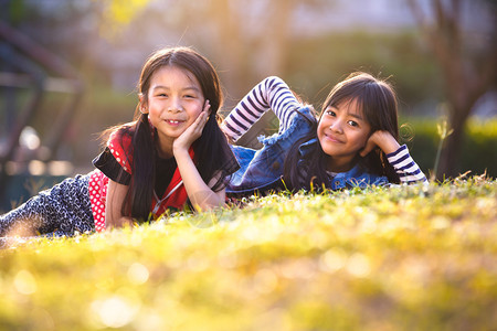 两个小亚洲女孩躺在阳光图片