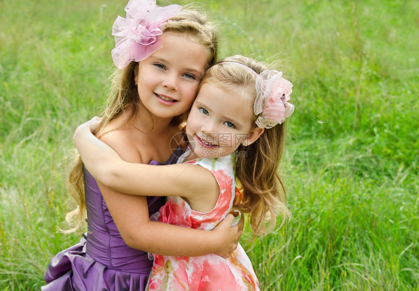 两个拥抱可爱小女孩的户外肖像图片