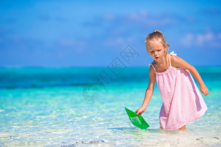 可爱的孩子在海里玩纸船图片