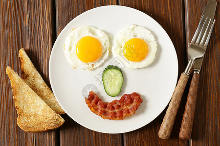 提供早餐煎蛋和吐司的滑稽面孔图片