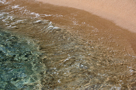 蓝色沿海透明水和沙子图片
