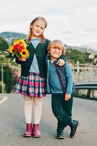 一个可爱的小孩的户外肖像与美丽的秋花束儿童学图片