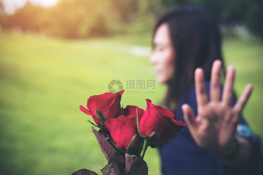 一位亚裔女在情人节拒绝她男友的红玫瑰花朵图片