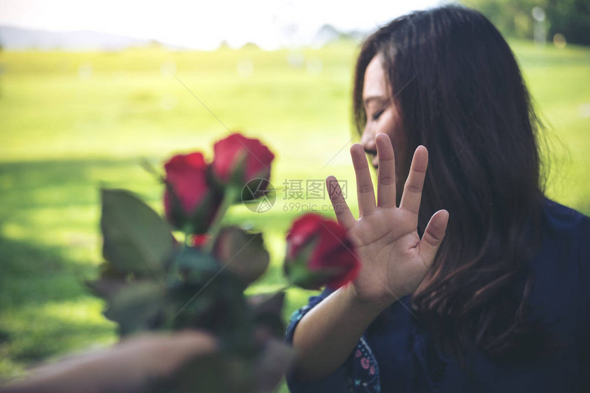 一位亚裔妇女拒绝她男朋友的红玫瑰花图片