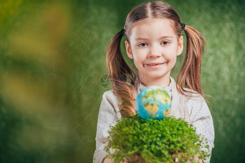 带花盆和地球模型的微笑儿童对模糊背景地球日概念图片