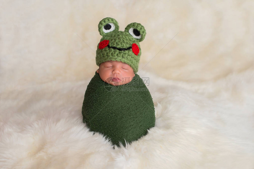 9天大的新生男孩戴着绿青蛙帽子图片